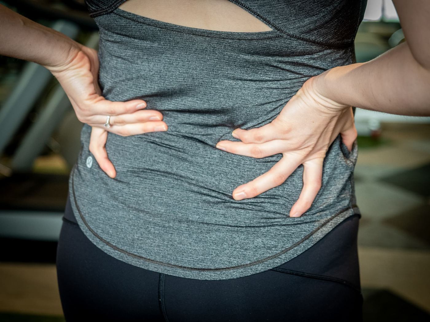 A patient holding her lower back