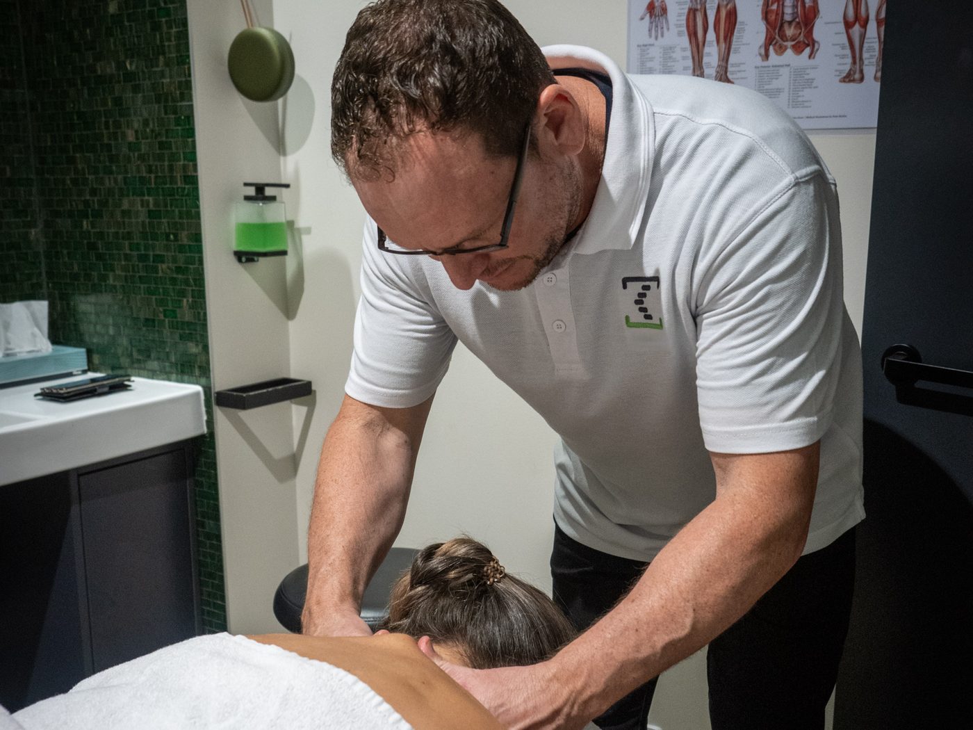 A therapist giving a patient remedial massage of the neck and shoulders