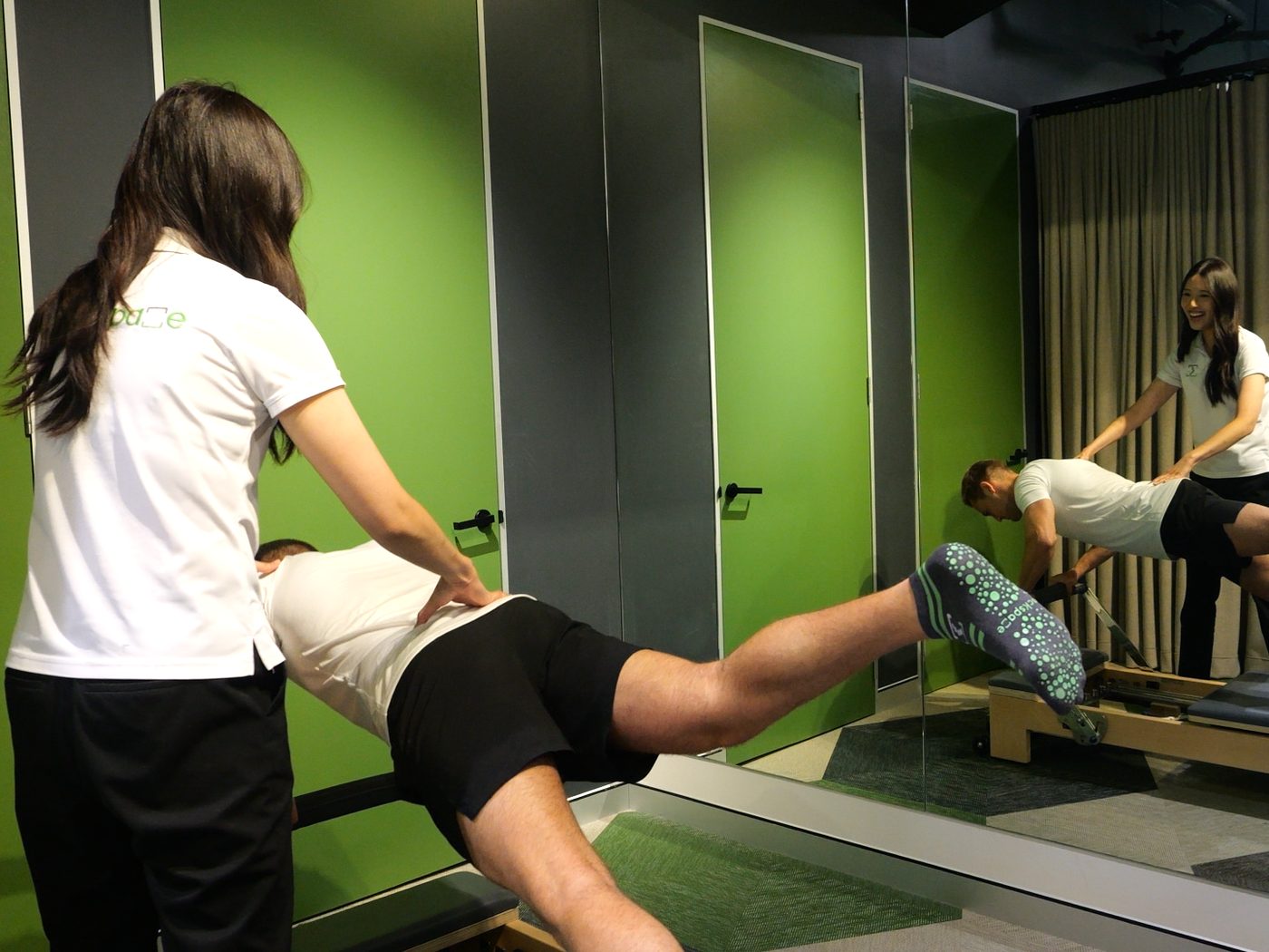 An exercise physiologist guiding a patient through a balance and strength exercise