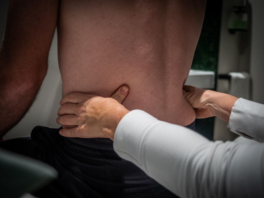 A clinician examining a patient's back