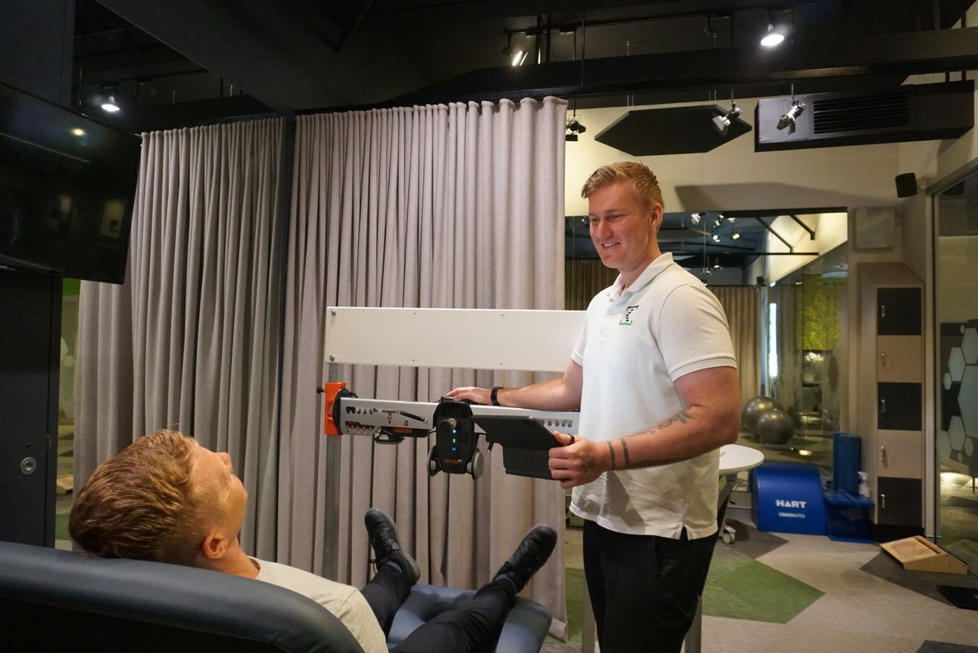 A clinician testing a patient's strength on specialised equipment