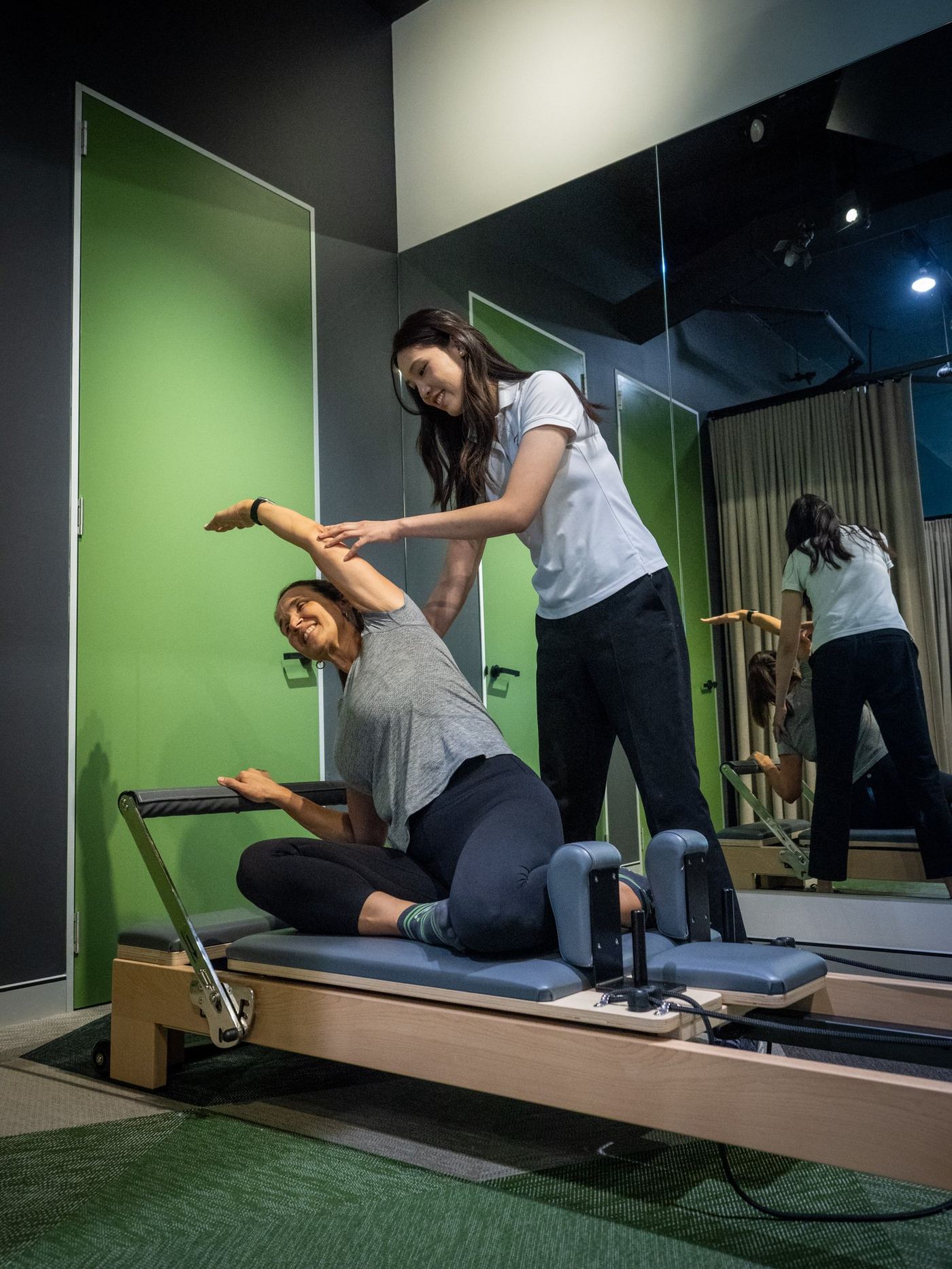 A patient doing Reformer Pilates with a clinician