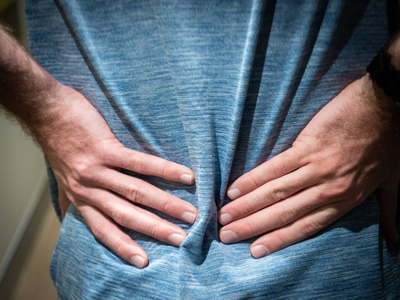 Hands pressed to the lower back